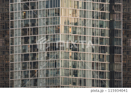 Architectural exterior of modern building facade with blue sky and clouds reflection in windows. Architectural exterior of modern building facade with blue sky and clouds reflection in windows. 115934041