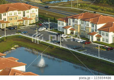 Aerial view of american apartment buildings in Florida residential area. New family condos as example of housing development in US suburbs Aerial view of american apartment buildings in Florida residential area. New family condos as example of housing development in US suburbs 115934486