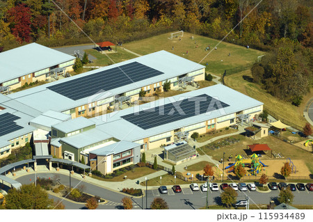 View from above of american school campus with roof covered with photovoltaic solar panels for producing of electrical clean energy 115934489