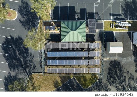 Aerial view of blue solar photovoltaic panels mounted on fenced backyard for producing clean ecological electric energy. Renewable electricity with zero emission concept 115934542