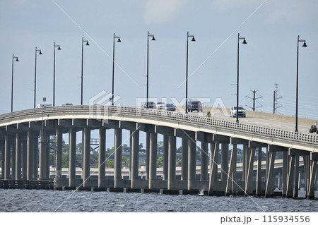 Barron Collier Bridge and Gilchrist Bridge in Florida with moving traffic. Transportation infrastructure in Charlotte County connecting Punta Gorda and Port Charlotte over Peace River Barron Collier Bridge and Gilchrist Bridge in Florida with moving traffic. Transportation infrastructure in Charlotte County connecting Punta Gorda and Port Charlotte over Peace River 115934556