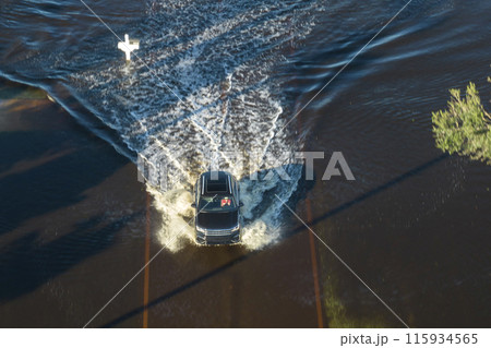 Hurricahe fainfall flooded Florida road with evacuating cars and surrounded with water houses in suburban residential area 115934565