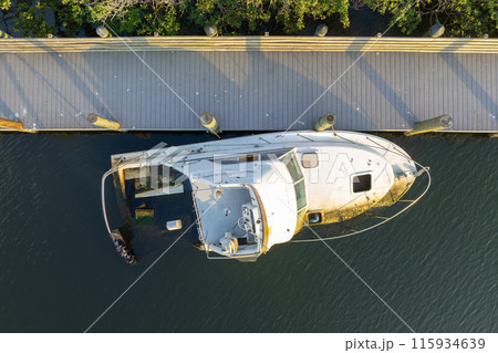 Aerial view of sunken sailboat on shallow bay waters after hurricane in Manasota, Florida Aerial view of sunken sailboat on shallow bay waters after hurricane in Manasota, Florida 115934639