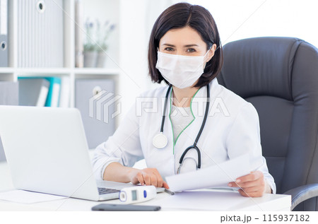 Doctor in medical face mask at work Doctor in medical face mask at work 115937182