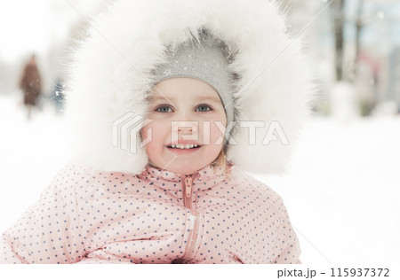 Smiling little girl on sled in winter Smiling little girl on sled in winter 115937372