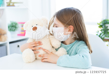 Cute little girl playing with teddy bear in light room Cute little girl playing with teddy bear in light room 115937725