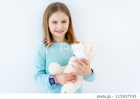 Smiling little girl with plush teddy in medical mask Smiling little girl with plush teddy in medical mask 115937745