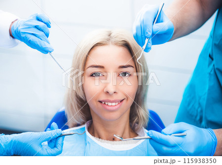 Dentists examinating blond smiling girl 115938350