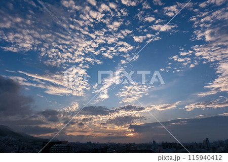 都市の夜明け。東の空が明るくなり雲がまだ昇る前の太陽に照らせら美しいグラデーションを見せる。神戸市内 115940412