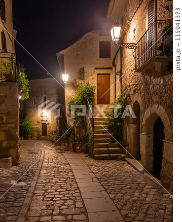 Cobblestone alley bathed in warm lights at dusk Cobblestone alley bathed in warm lights at dusk 115941373