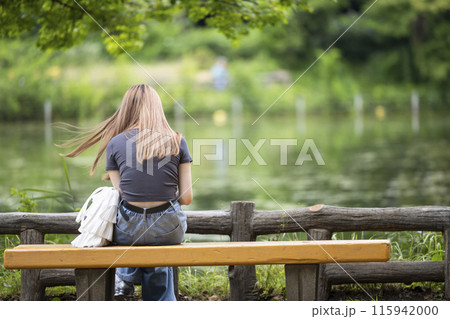 一人で公園のベンチに座る孤独な若い女性のイメージ 一人で公園のベンチに座る孤独な若い女性のイメージ 115942000