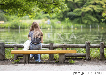 一人で公園のベンチに座る孤独な若い女性のイメージ 一人で公園のベンチに座る孤独な若い女性のイメージ 115942002