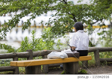 一人で公園のベンチに座る孤独な中年女性のイメージ 一人で公園のベンチに座る孤独な中年女性のイメージ 115942016