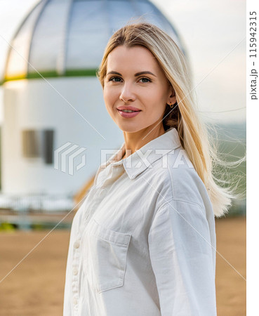 Woman smiling outdoors at sunset near a modern building 115942315