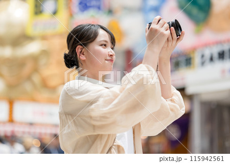都会の繁華街を観光しながら趣味の一眼レフで写真を撮るカメラ女子|カメラマンイメージ 都会の繁華街を観光しながら趣味の一眼レフで写真を撮るカメラ女子|カメラマンイメージ 115942561