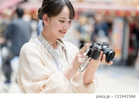 都会の繁華街を観光しながら趣味の一眼レフで写真を撮るカメラ女子｜カメラマンイメージ 115942566