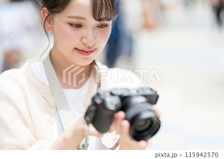 都会の繁華街を観光しながら趣味の一眼レフで写真を撮るカメラ女子|カメラマンイメージ 都会の繁華街を観光しながら趣味の一眼レフで写真を撮るカメラ女子|カメラマンイメージ 115942570