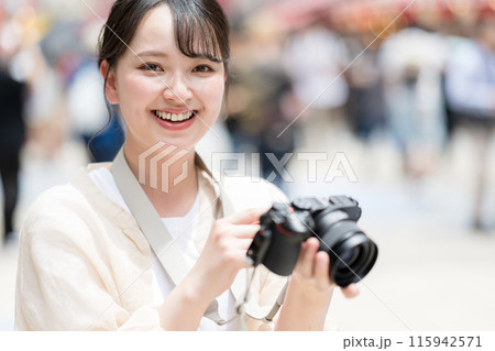 都会の繁華街を観光しながら趣味の一眼レフで写真を撮るカメラ女子｜カメラマンイメージ 115942571