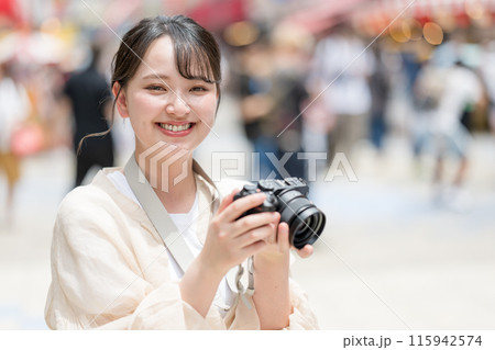 都会の繁華街を観光しながら趣味の一眼レフで写真を撮るカメラ女子|カメラマンイメージ 都会の繁華街を観光しながら趣味の一眼レフで写真を撮るカメラ女子|カメラマンイメージ 115942574