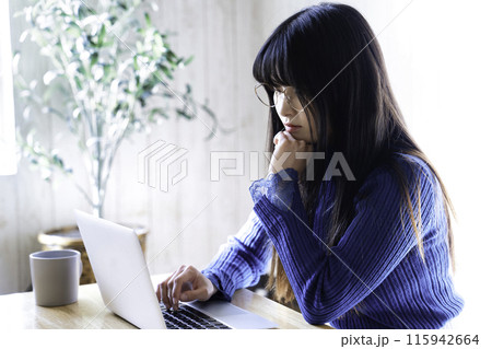 部屋でノートパソコンを使う若い女性 部屋でノートパソコンを使う若い女性 115942664