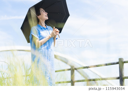 日傘をさして散歩する若い女性　ライフスタイルイメージ 115943034