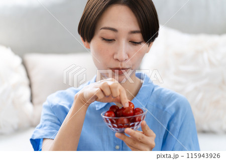 ミニトマトを食べる若い女性 ライフスタイルイメージ ミニトマトを食べる若い女性 ライフスタイルイメージ 115943926