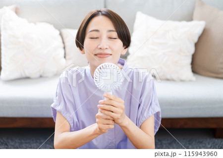 ハンドファンを使う若い女性　ライフスタイルイメージ 115943960