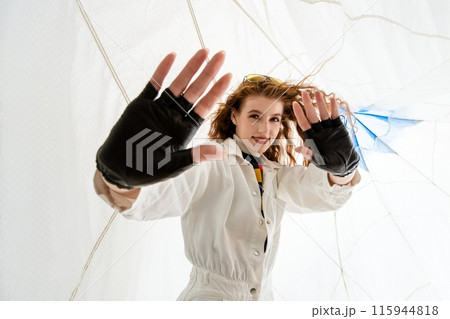 Young Woman Wearing Black Fingerless Gloves Poses With White Background 115944818