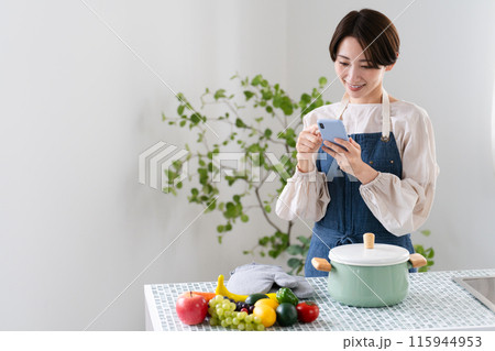 エプロン姿で料理する若い女性 ライフスタイルイメージ エプロン姿で料理する若い女性 ライフスタイルイメージ 115944953