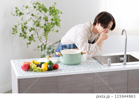 エプロン姿で料理する若い女性　ライフスタイルイメージ 115944963