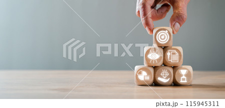 Hand Stacking Wooden Blocks with Business Icons Representing Objective and Key Results Concept for Strategic Planning and Performance Management 115945311