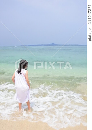 浜辺に佇むワンピースを着た女の子 115947275
