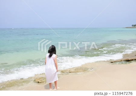 浜辺に佇むワンピースを着た女の子 浜辺に佇むワンピースを着た女の子 115947276
