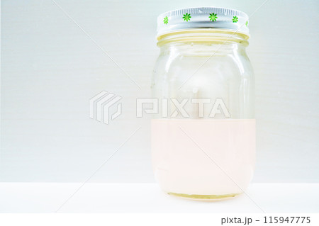 白背景にカレンデュラの花を除いた後の薄ピンク色の自家製の天然花酵母液 白背景にカレンデュラの花を除いた後の薄ピンク色の自家製の天然花酵母液 115947775