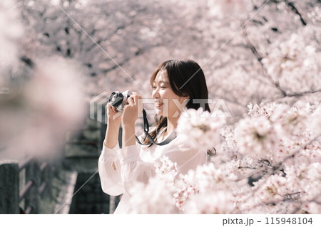 桜を見ながら楽しんでいる女性 115948104