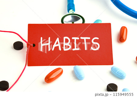 Concept. Copy space. Text HABITS on a red card on a stethoscope with pills on the surface Concept. Copy space. Text HABITS on a red card on a stethoscope with pills on the surface 115949555