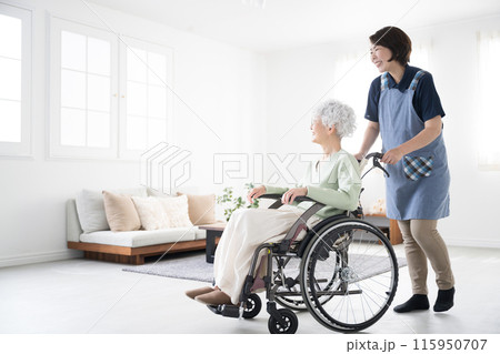 自宅での車椅子を押す介護士とシニア女性の全身 訪問看護や通所介護(デイサービス) 自宅での車椅子を押す介護士とシニア女性の全身 訪問看護や通所介護(デイサービス) 115950707
