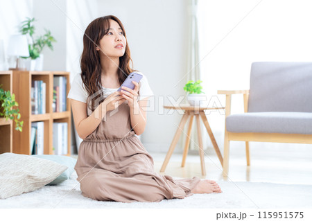 リビングでくつろぐ若い女性 リビングでくつろぐ若い女性 115951575