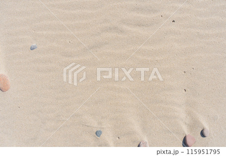 Sand and small stones on the beach. Sand texture. Brown sand. Abstract background 115951795
