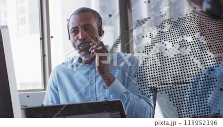 Image of spinning globe against african american man talking on phone headset at office 115952196