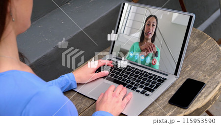 Image of media icons over caucasian woman having laptop image call with biracial colleague 115953590