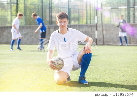 Youth football player sitting on field 115955574