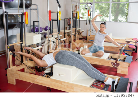 Young woman training her abs on pilates machine Young woman training her abs on pilates machine 115955847