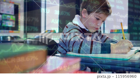Image of trading board over caucasian boy writing in book at classroom Image of trading board over caucasian boy writing in book at classroom 115956960