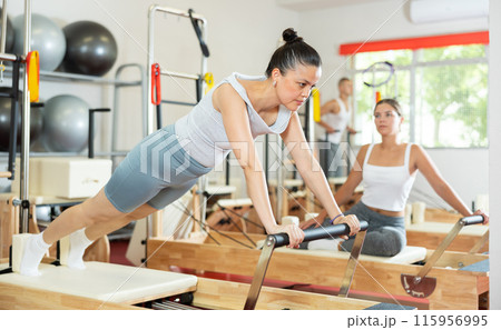 Young woman training her abs on pilates reformer 115956995