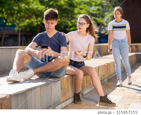 Teen girl trying to get attention of boy with phone 115957255