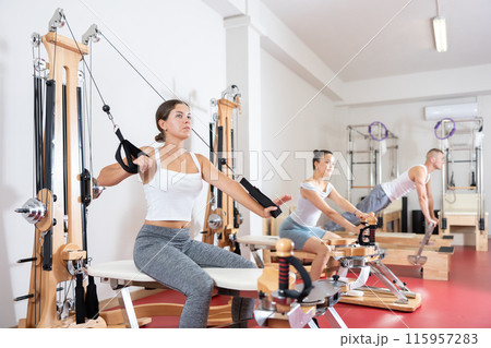 Young woman training her arms using straps 115957283
