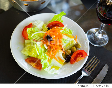 Vitamin salad of fresh vegetables, tomato, olives, onions is prepared for home snack 115957410