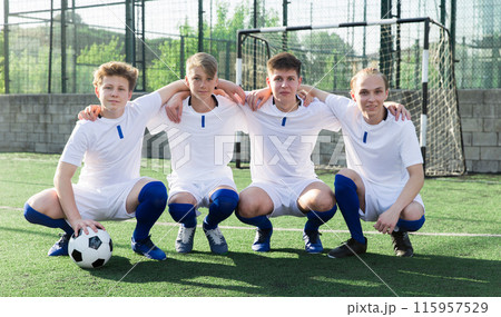 Youth football players sitting on field 115957529