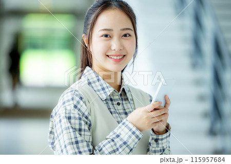 学校でスマホを操作する若い女性 学校でスマホを操作する若い女性 115957684